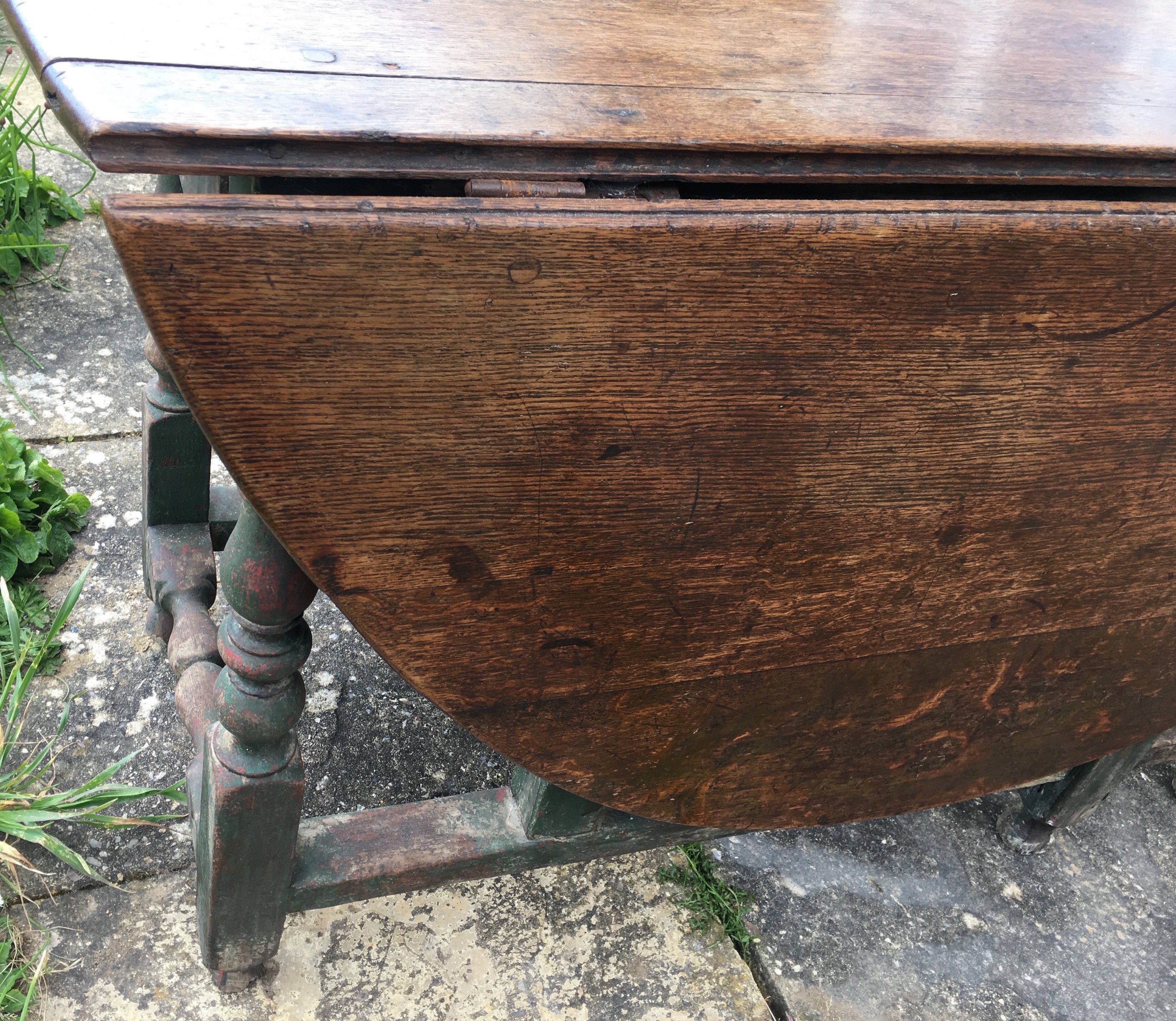 An 18th century oak gateleg dining table, the turned underframe with traces of old paint, length 123cm, depth extended 134cm, height 72cm *Please note the sale commences at 9am.